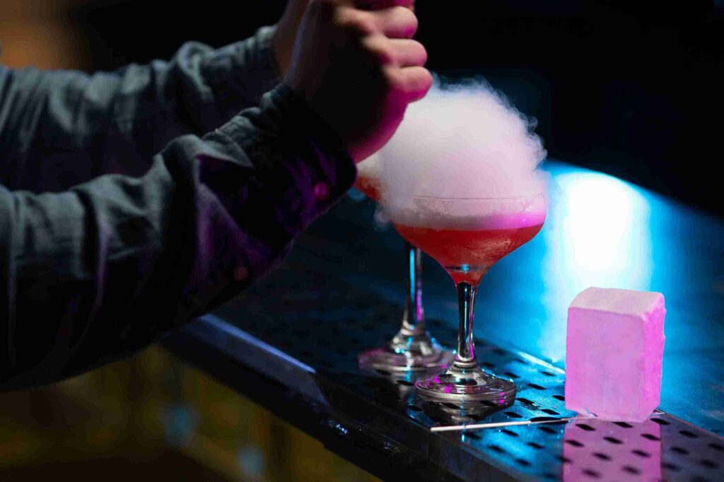 human hand with two cotton candy drinks glass