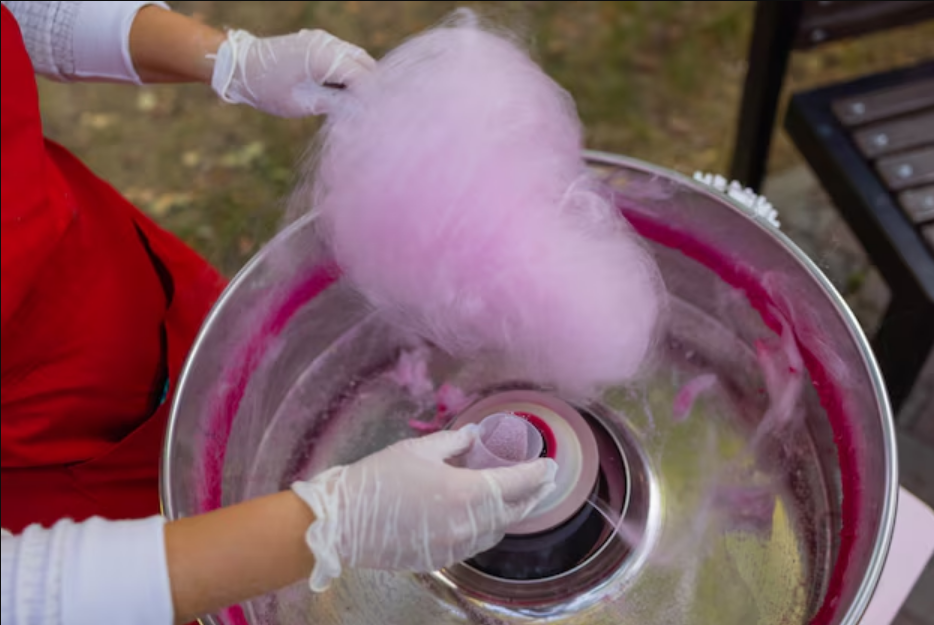candy floss in hand and a machine of it